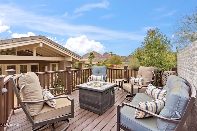 wooden terrace with an outdoor living space with a fire pit