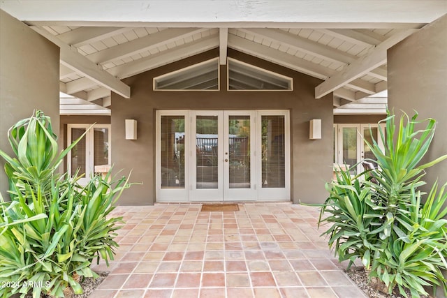 view of exterior entry featuring french doors and a patio area