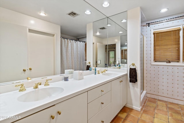 bathroom with tile patterned floors, vanity, and walk in shower