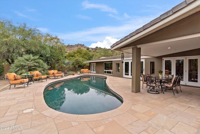 view of pool with an outdoor hangout area, a patio, and french doors