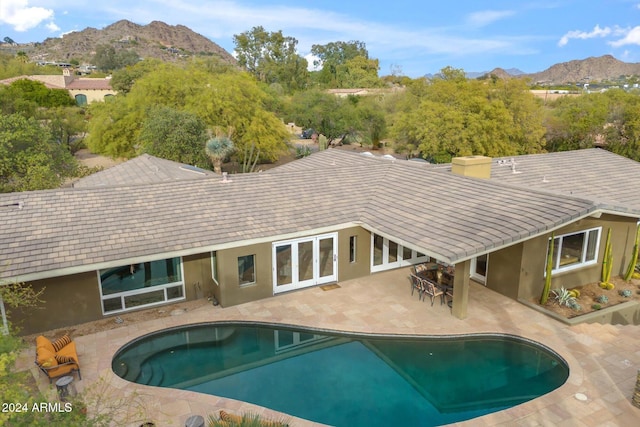 view of swimming pool featuring a mountain view, french doors, and a patio area