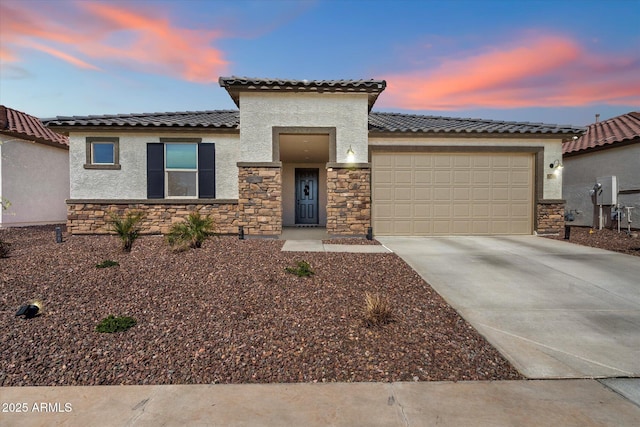 17140 W Running Deer Trl, Surprise, AZ 85387 - mediterranean / spanish-style house featuring stone siding, stucco siding, an attached garage, concrete driveway, and a tile roof