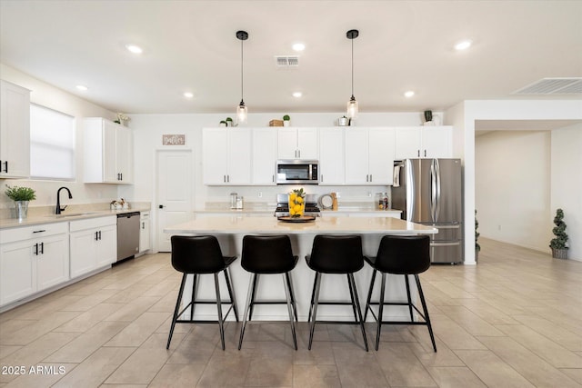 17140 W Running Deer Trl, Surprise, AZ 85387 - kitchen featuring stainless steel appliances, a sink, a kitchen breakfast bar, a center island, and light countertops