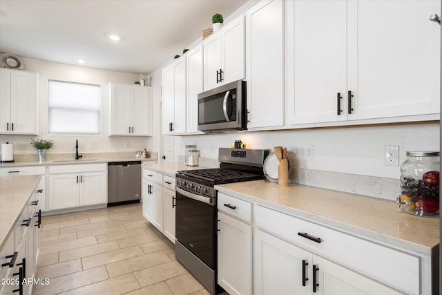 17140 W Running Deer Trl, Surprise, AZ 85387 - kitchen featuring stainless steel appliances, a sink, white cabinetry, light stone counters, and recessed lighting