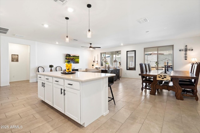 17140 W Running Deer Trl, Surprise, AZ 85387 - kitchen featuring a kitchen island, light countertops, white cabinetry, decorative light fixtures, and a ceiling fan