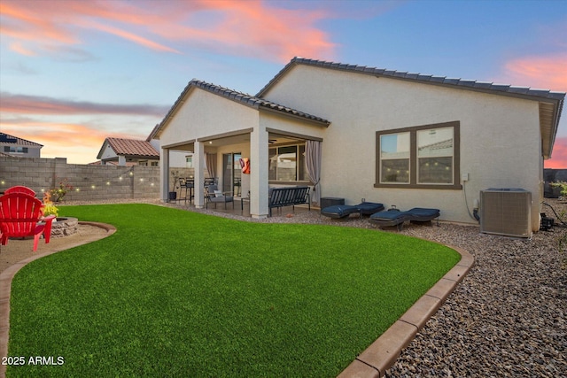 17140 W Running Deer Trl, Surprise, AZ 85387 - back of house at dusk featuring central air condition unit, a patio area, and stucco siding