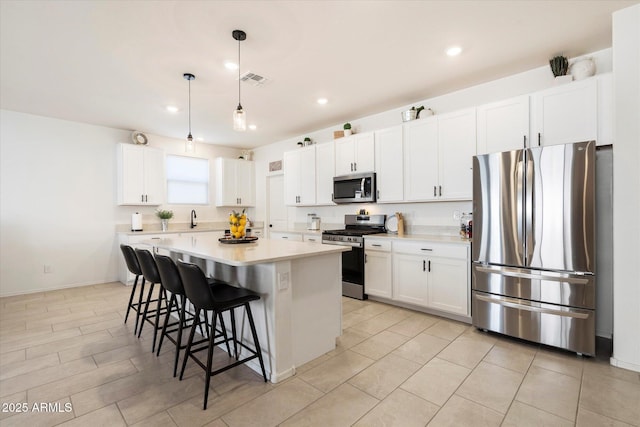 17140 W Running Deer Trl, Surprise, AZ 85387 - kitchen with stainless steel appliances, a kitchen breakfast bar, a sink, light countertops, and white cabinetry