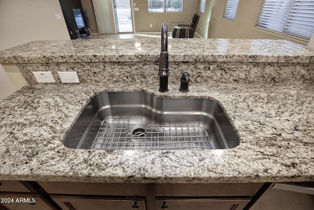 room details featuring light stone countertops and sink