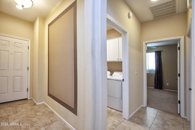 hallway featuring washer and clothes dryer and light tile patterned flooring