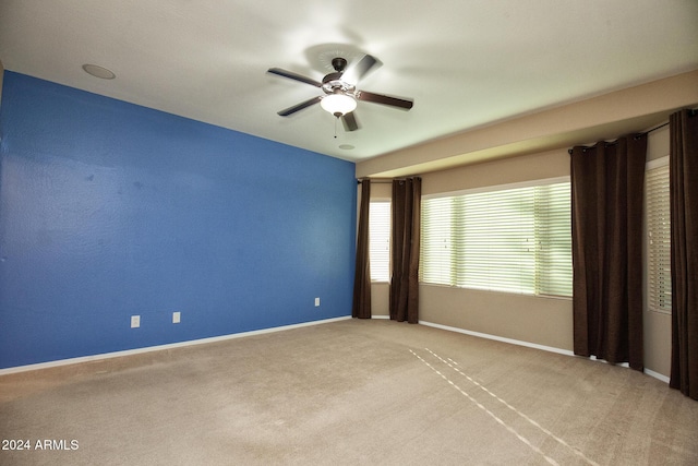 empty room with ceiling fan and light carpet