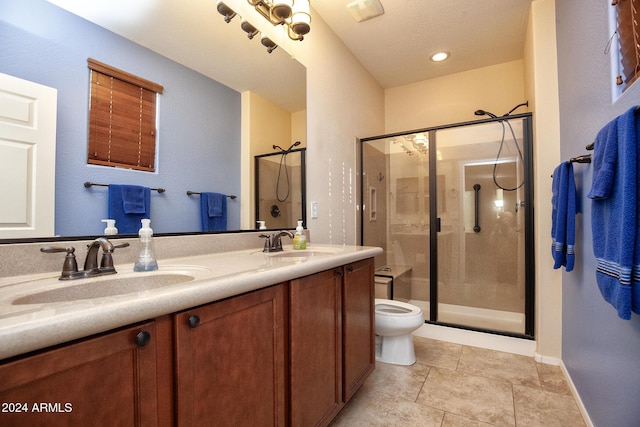 bathroom with toilet, tile patterned flooring, vanity, and walk in shower