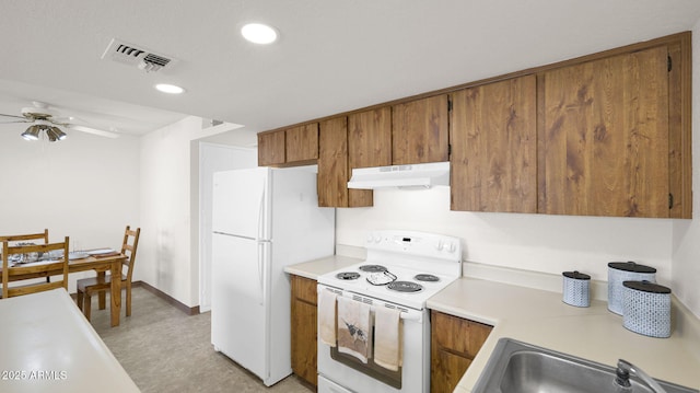 455 N Tegner St Unit 59, Wickenburg, AZ 85390 - kitchen with white appliances, under cabinet range hood, a sink, a ceiling fan, and brown cabinetry