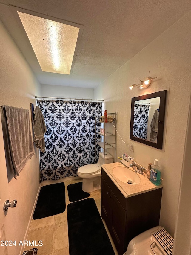 bathroom with vanity, toilet, a textured ceiling, and curtained shower