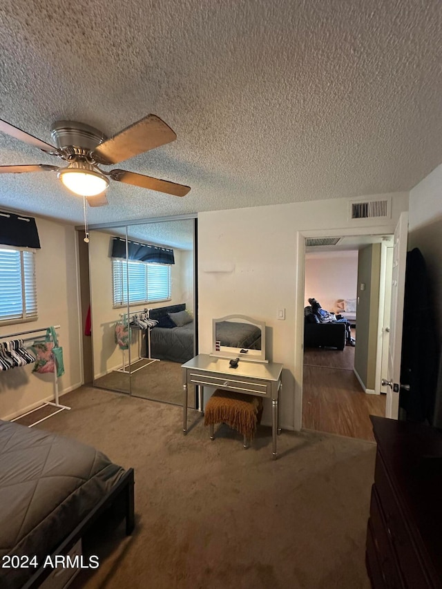 carpeted living room with a textured ceiling, ceiling fan, and plenty of natural light