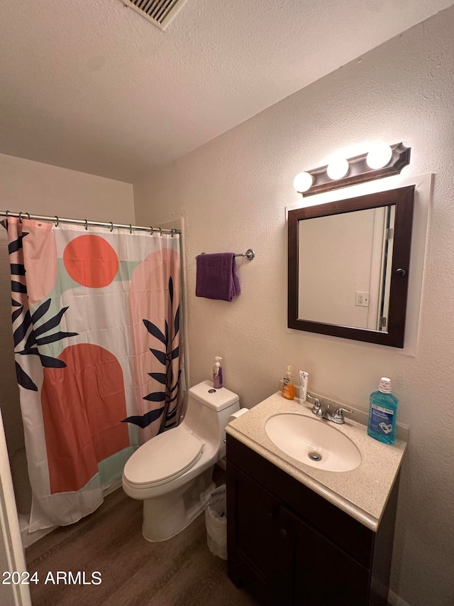 bathroom featuring vanity, toilet, a textured ceiling, walk in shower, and hardwood / wood-style floors