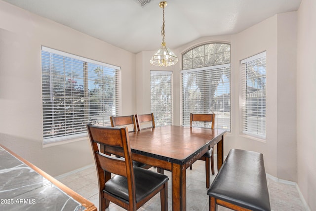 dining area with a notable chandelier and vaulted ceiling