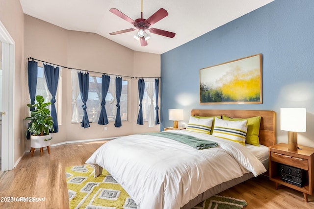 bedroom with ceiling fan, lofted ceiling, and light hardwood / wood-style flooring