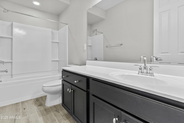 full bathroom with shower / bathing tub combination, vanity, hardwood / wood-style flooring, and toilet