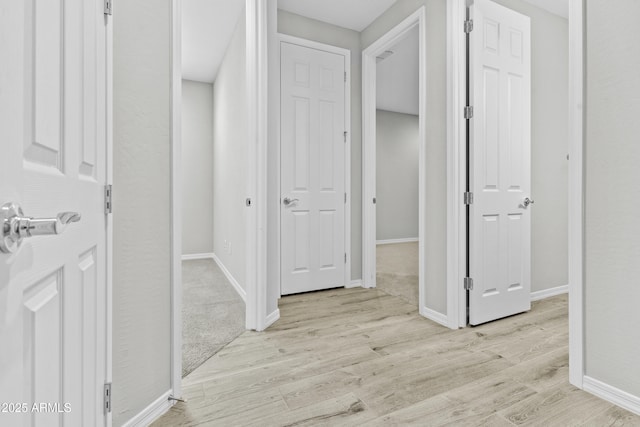 hallway with light hardwood / wood-style floors