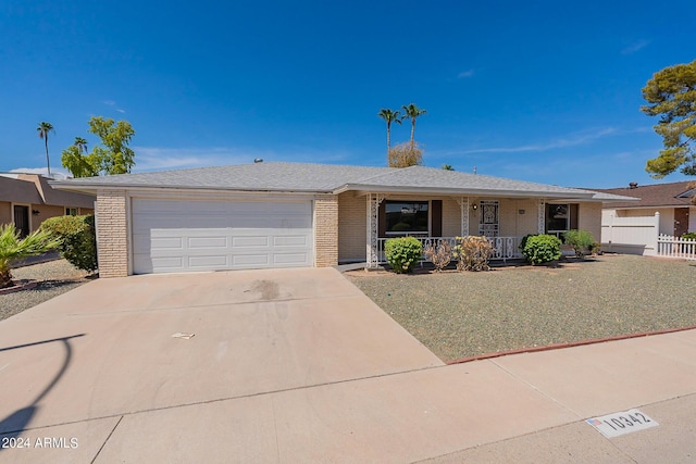 ranch-style house with a porch, concrete driveway, brick siding, and a garage