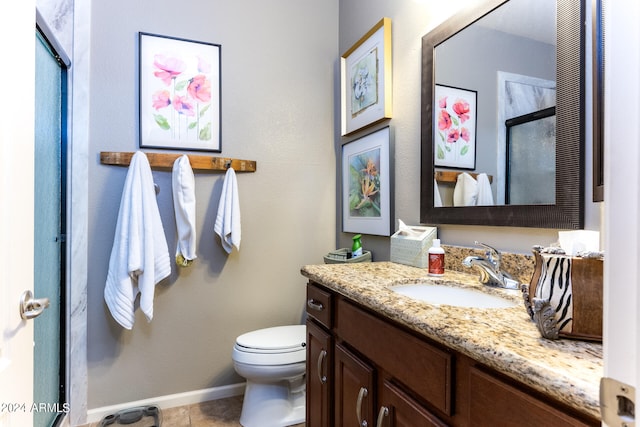 bathroom featuring toilet, tile patterned floors, walk in shower, and vanity