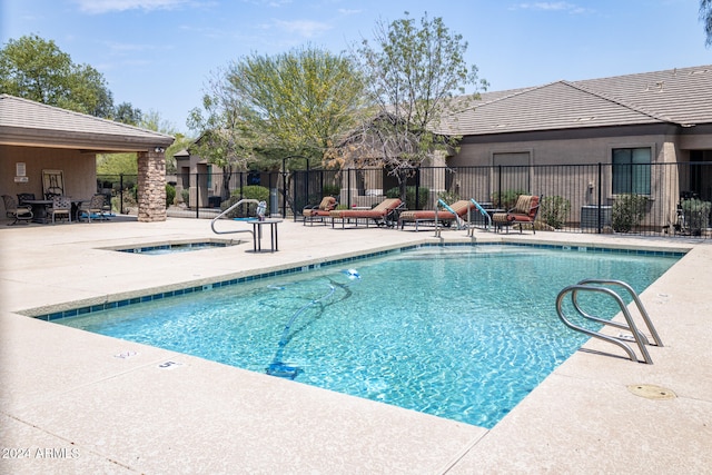 view of pool with a community hot tub and a patio area