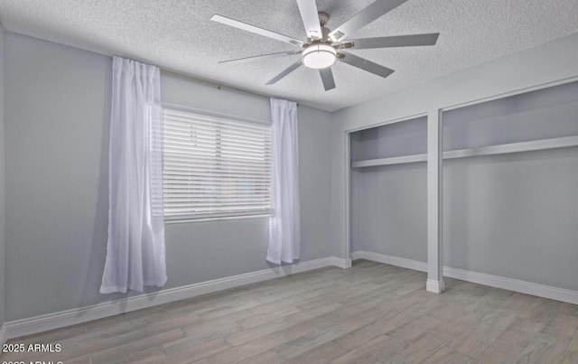 3646 N 67th Ave Unit 64, Phoenix, AZ 85033 - unfurnished bedroom with wood finished floors, a textured ceiling, two closets, ceiling fan, and baseboards