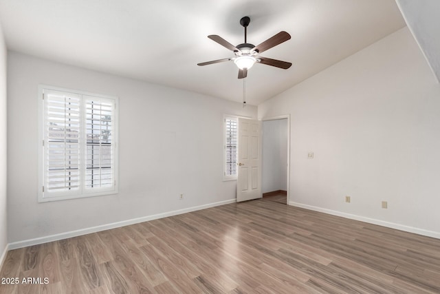 unfurnished room with ceiling fan, baseboards, wood finished floors, and lofted ceiling