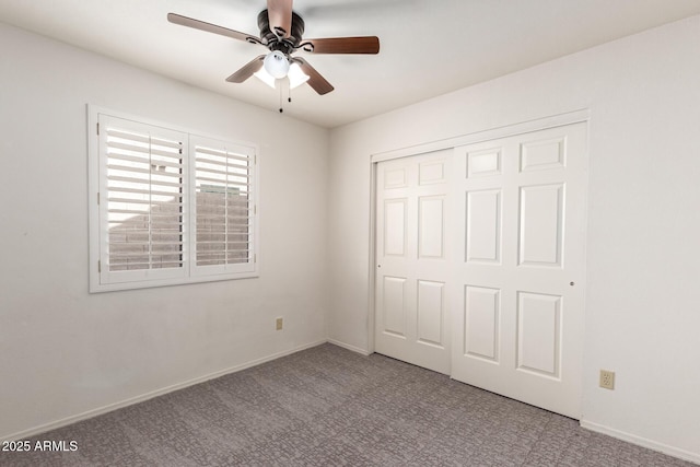 unfurnished bedroom with a closet, baseboards, a ceiling fan, and carpet