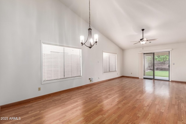 interior space with baseboards, light wood-type flooring, high vaulted ceiling, and ceiling fan with notable chandelier