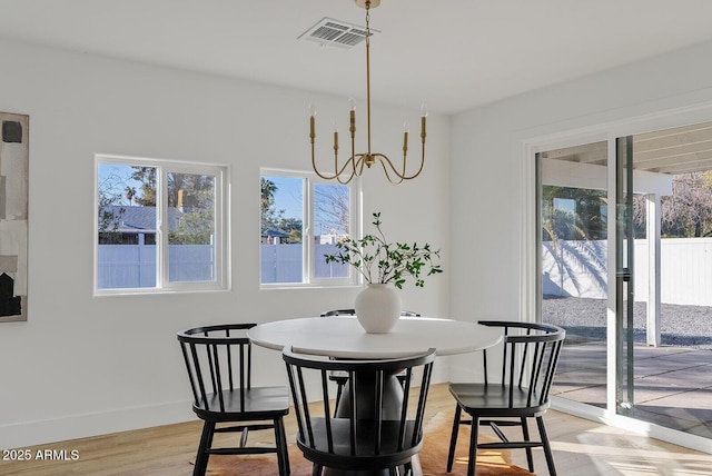 dining space featuring a notable chandelier and light hardwood / wood-style floors