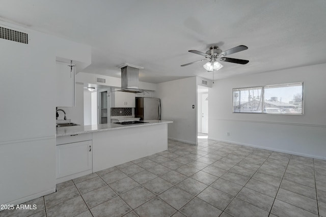 kitchen with sink, stainless steel fridge, white cabinetry, black electric stovetop, and island exhaust hood