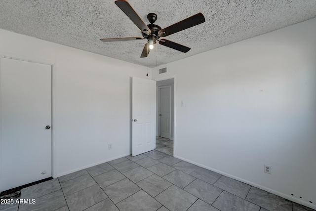 unfurnished bedroom featuring ceiling fan and a textured ceiling