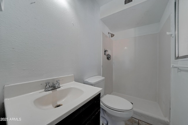 bathroom featuring vanity, toilet, and walk in shower