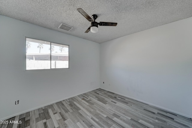 empty room with ceiling fan, a textured ceiling, and light hardwood / wood-style floors