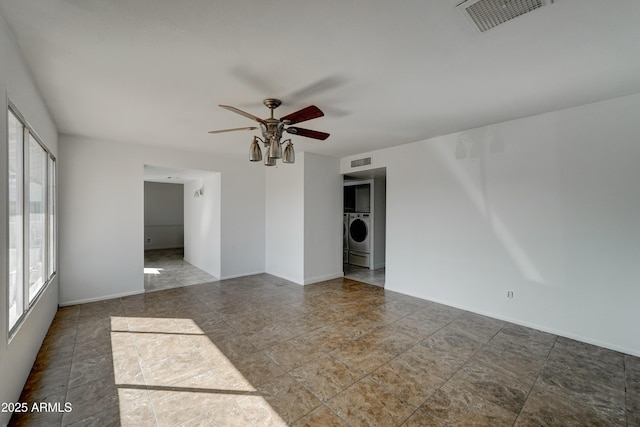 unfurnished room with ceiling fan and washer / dryer