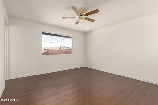 empty room with ceiling fan and dark hardwood / wood-style flooring