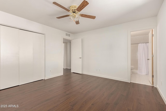 unfurnished bedroom featuring a closet, ceiling fan, connected bathroom, and dark hardwood / wood-style flooring