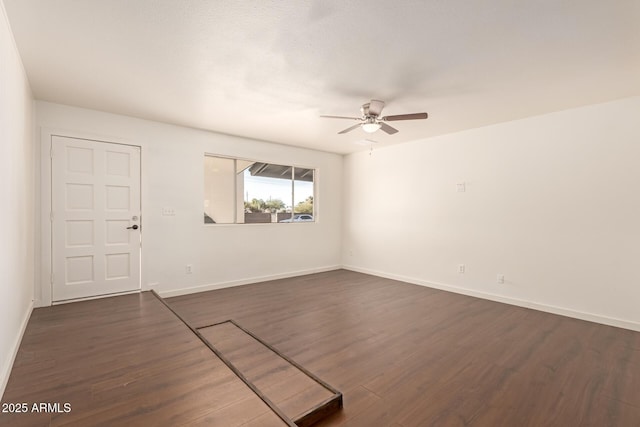 unfurnished room featuring dark wood-type flooring and ceiling fan