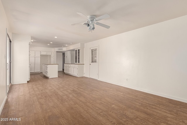 unfurnished living room with ceiling fan and hardwood / wood-style floors