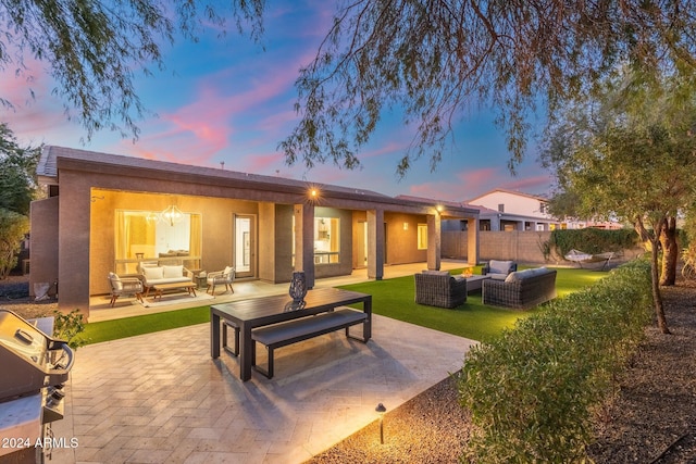 back house at dusk featuring outdoor lounge area and a patio area