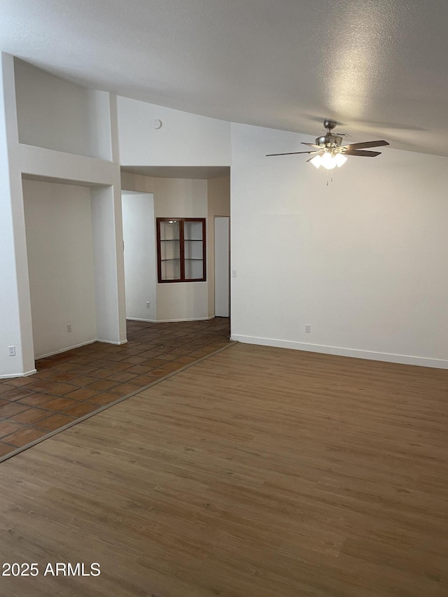 unfurnished room featuring lofted ceiling, ceiling fan, dark hardwood / wood-style flooring, and a textured ceiling