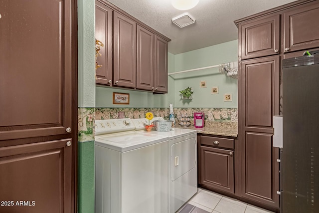 4648 W Misty Willow Ln, Glendale, AZ 85310 - laundry area featuring cabinet space, washing machine and dryer, light tile patterned floors, and a textured ceiling