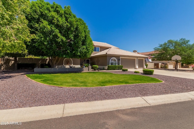 4648 W Misty Willow Ln, Glendale, AZ 85310 - mediterranean / spanish-style house featuring an attached garage, a tiled roof, a front yard, stucco siding, and driveway