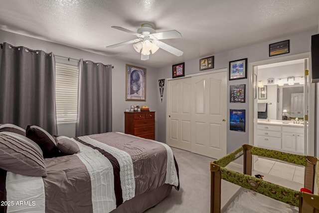 4648 W Misty Willow Ln, Glendale, AZ 85310 - bedroom with a closet, light colored carpet, a textured ceiling, ceiling fan, and ensuite bath