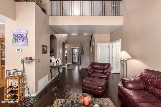 4648 W Misty Willow Ln, Glendale, AZ 85310 - living room with arched walkways, a towering ceiling, wood-type flooring, stairway, and baseboards