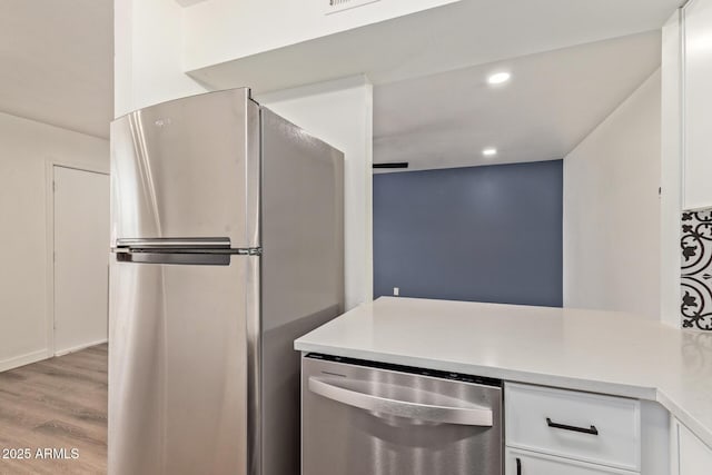 kitchen featuring white cabinetry, hardwood / wood-style floors, and stainless steel appliances