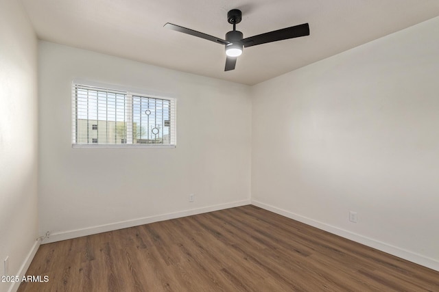 spare room featuring dark wood-type flooring and ceiling fan