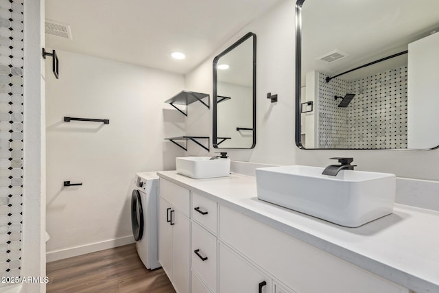 bathroom with wood-type flooring, washer / dryer, vanity, and a shower