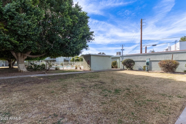 view of front of house with a pool and a front lawn